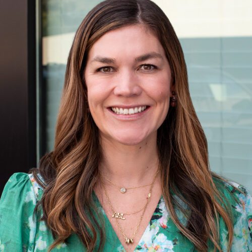 Robbie (Branstrom) Adams woman with a green dress and long brown hair smiling