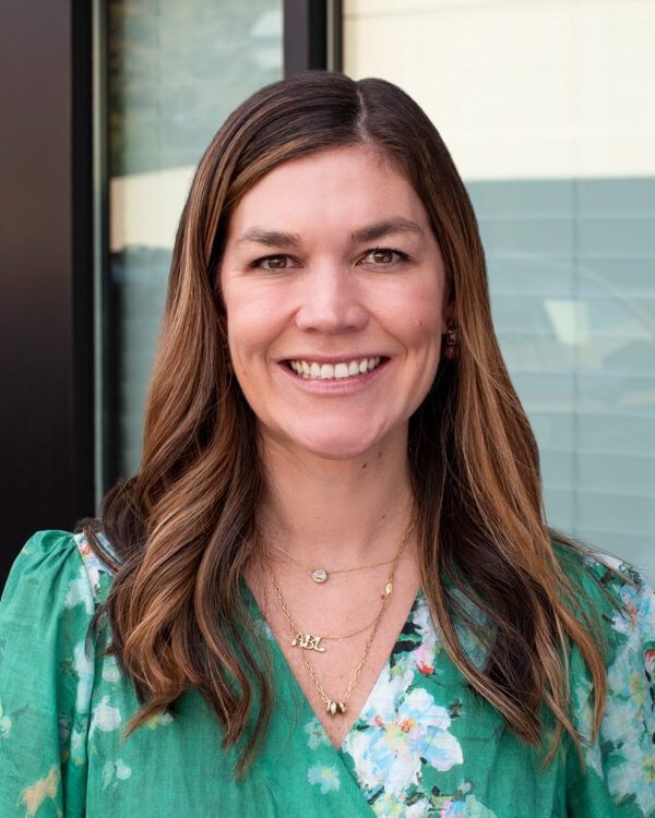 Robbie (Branstrom) Adams woman with a green dress and long brown hair smiling