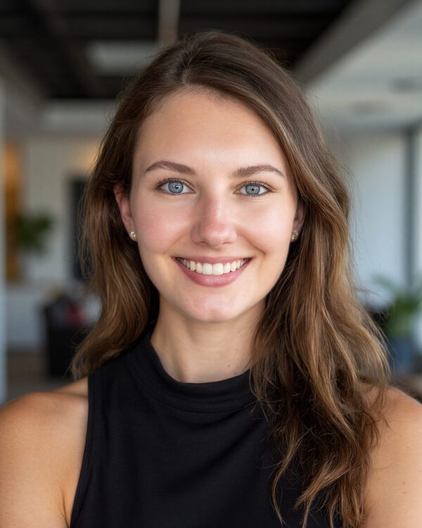 Rhead McEneny brown haired woman smiling inside wearing a black sleeveless top