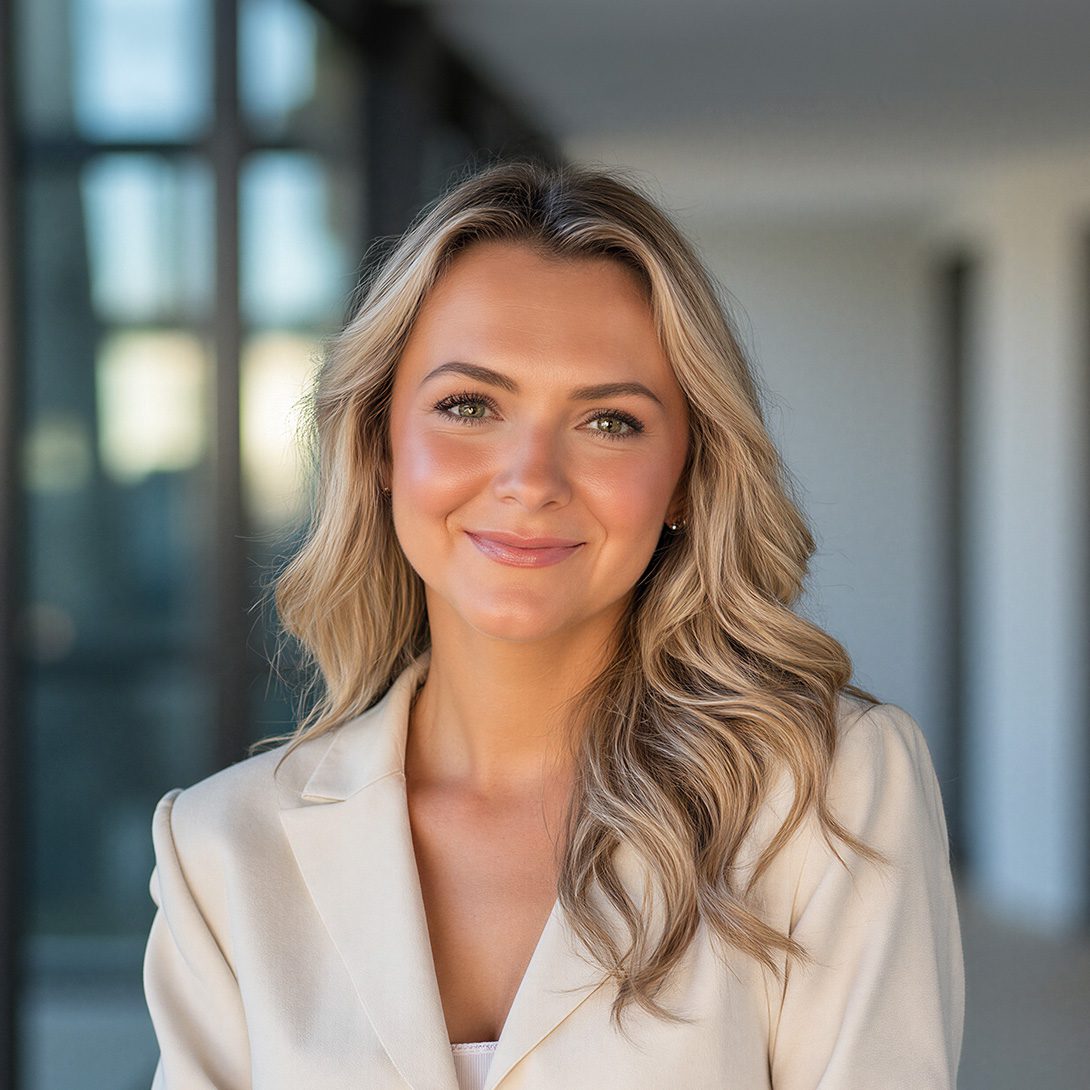 Ferris Edwards young woman with long blonde hair in a cream business suite smiling indoors