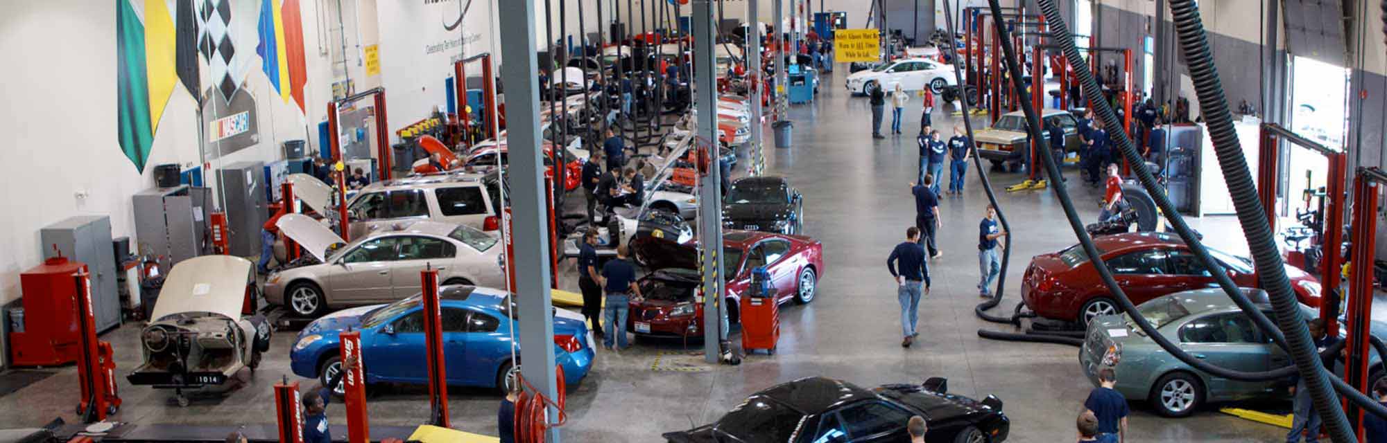 NASCAR-Technical-Institute- interior large garage with cars and people