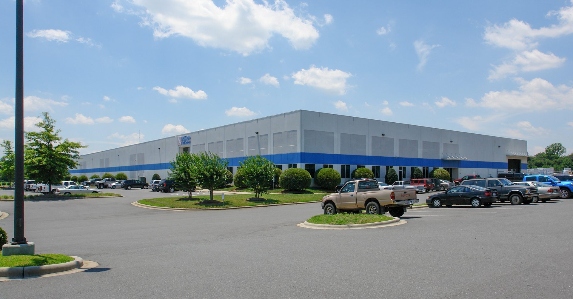 Builders FirstSource warehouse building white and blue on a sunny blue sky day