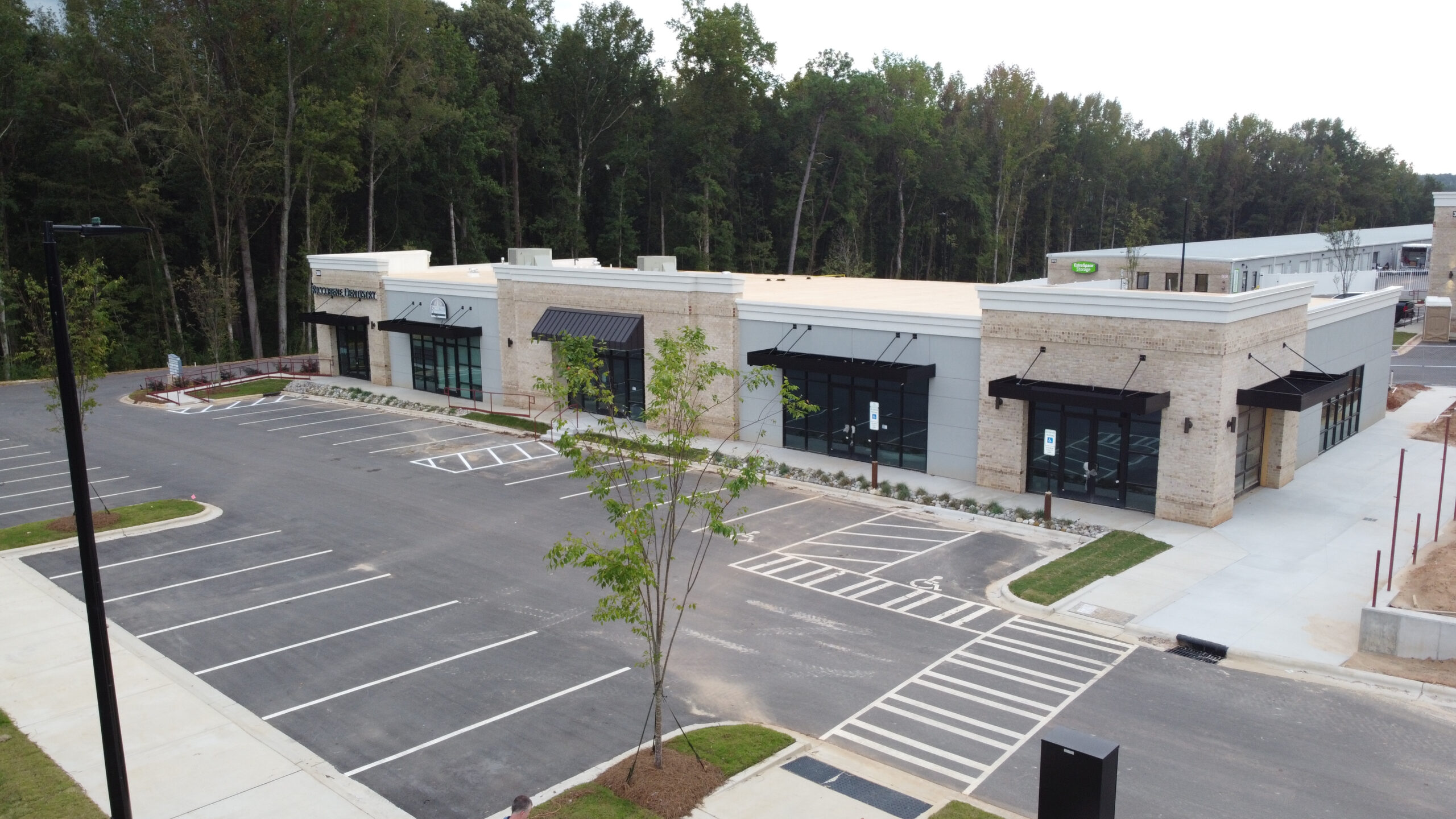 Aerial view of white buildings with parking lot