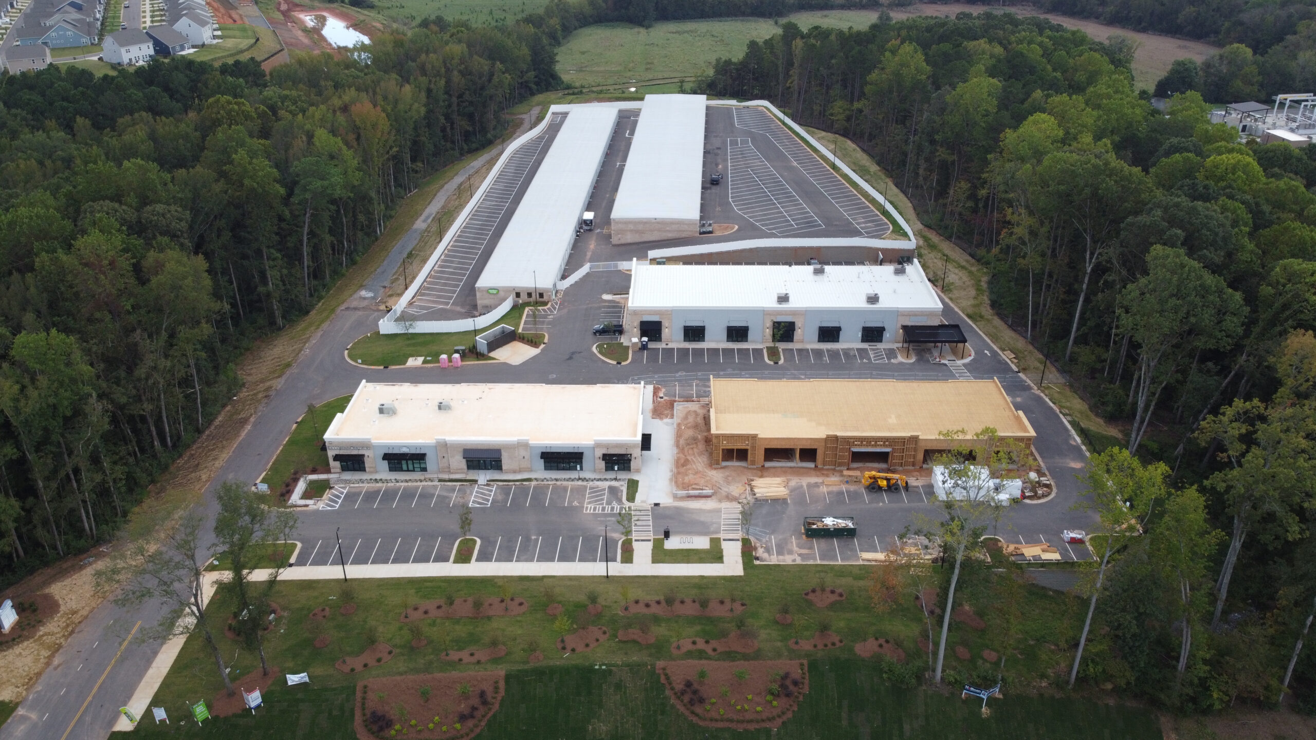 Aerial view of white buildings with parking lot