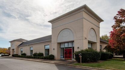 9835 Pineville-Matthews Road light brick 1-story retail building with red doors exterior