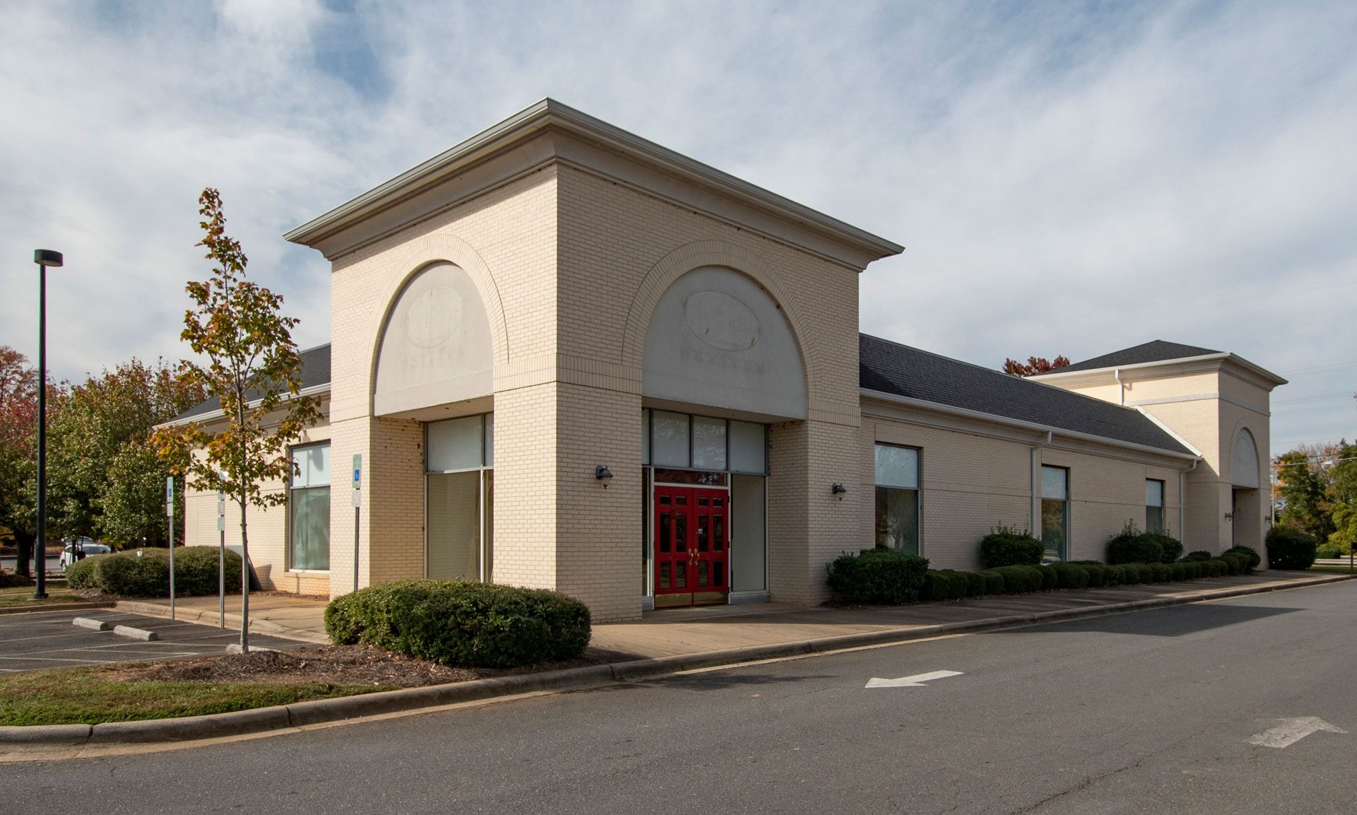 9835 Pineville-Matthews Road light brick 1-story retail building with red doors exterior