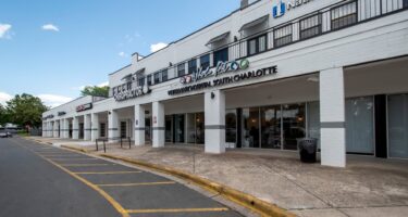 Whole Pet Veterinary Hospital exterior entrance a white brick 2-story retail building