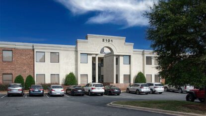 White 2 Story Office Building with Columns and parking lot in front