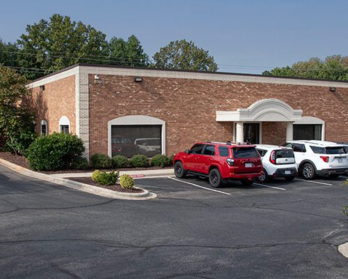 Exterior of Brick Office Building with cars in front