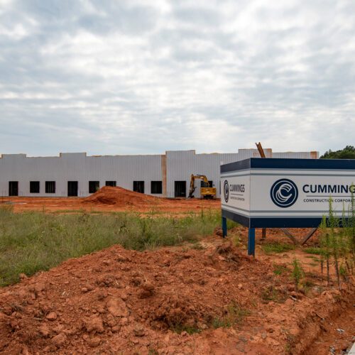 Clear Creek industrial flex building under construction with red dirt in foreground and a Cummings sign on site