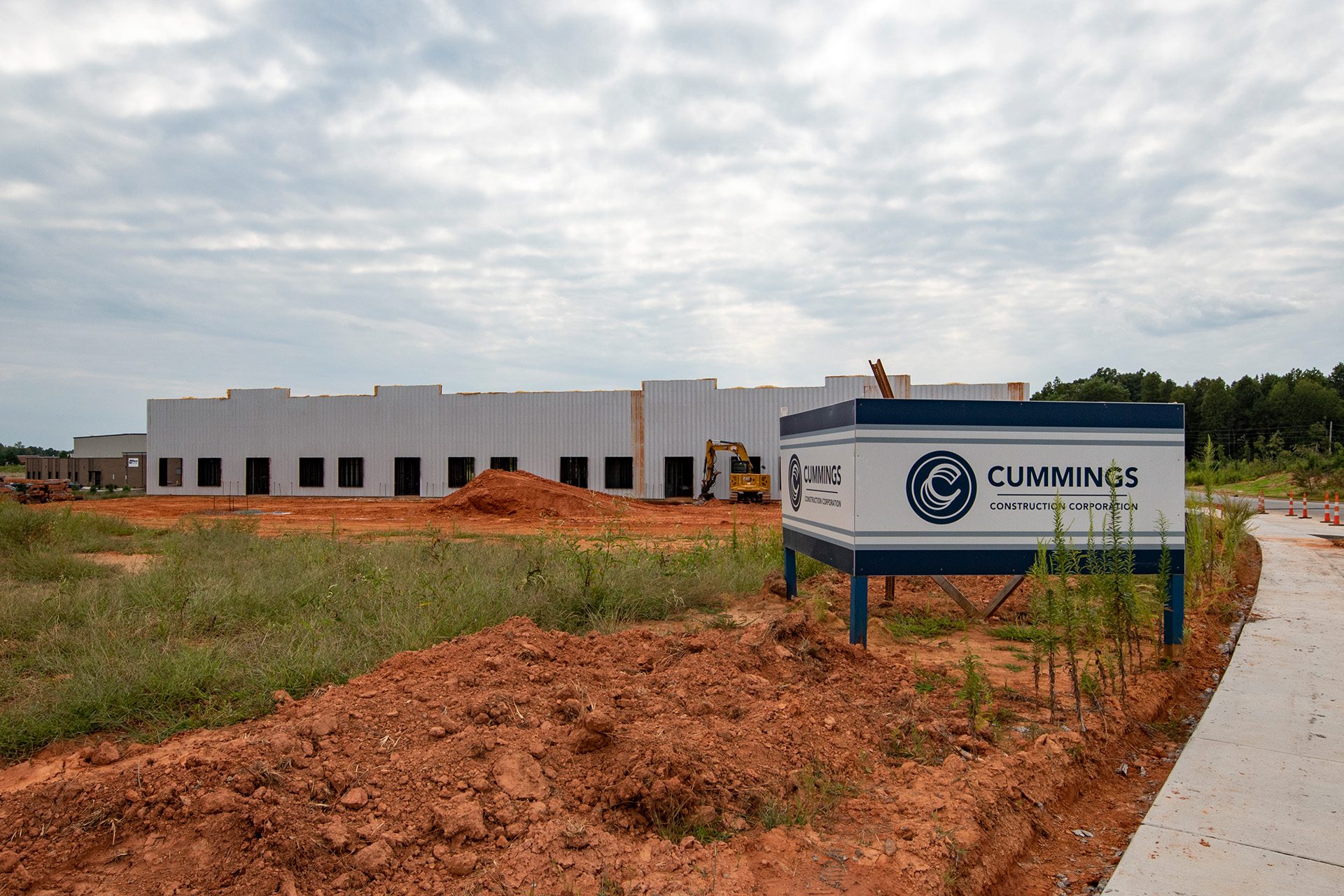 Clear Creek industrial flex building under construction with red dirt in foreground and a Cummings sign on site