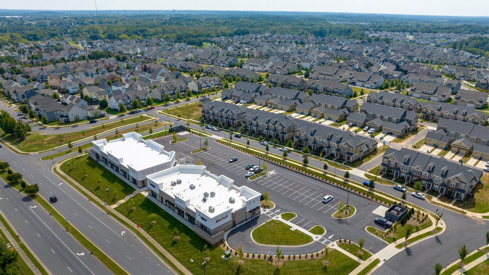 Shoppes at McCullough buildings in aerial with McCullough neighborhood rooftops in background