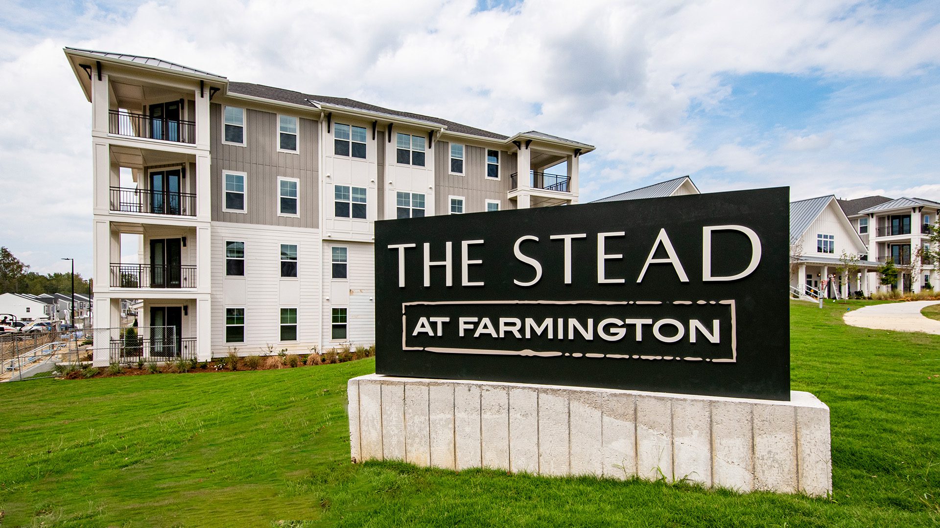 The Stead at Farmington sign for 3-story apartment buildings in the background