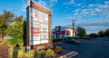 Madison Corners pylon sign listing tenants in shopping center.