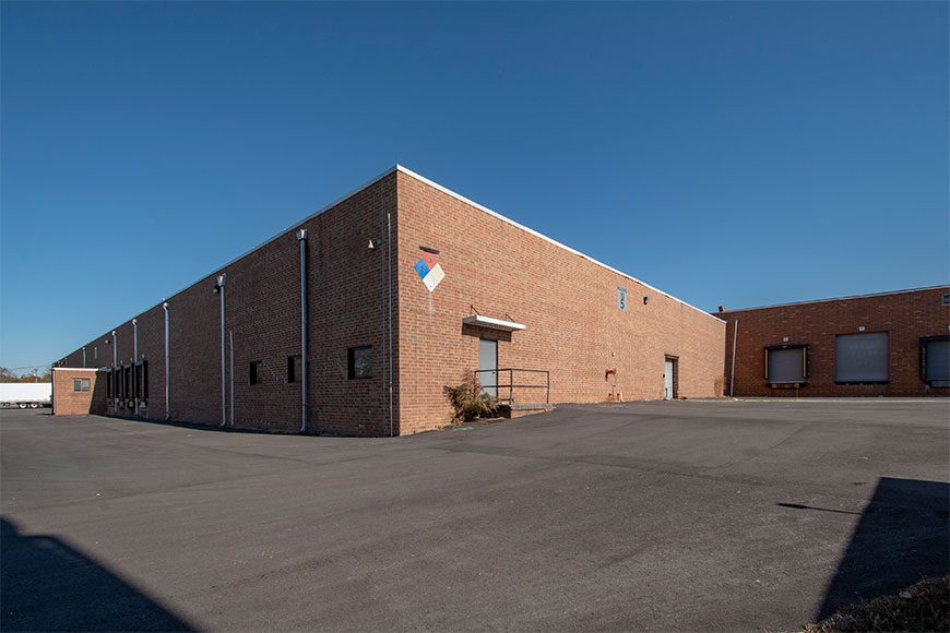 exterior of brick industrial building with blue skies