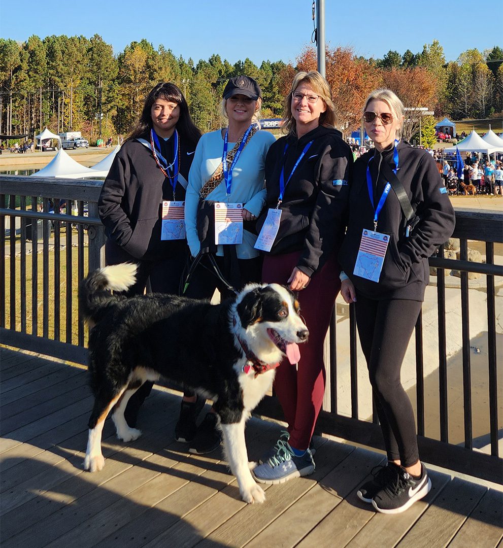 MPV Team at JDRF One Walk - 4 women and a large dog standing on boardwalk smiling
