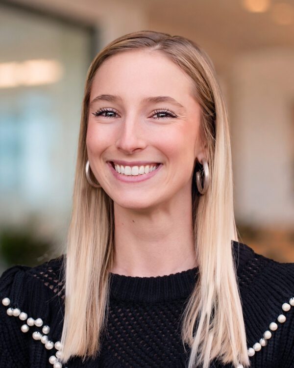Morgan Lucas development manager young blonde woman smiling in an office setting in a black sweater