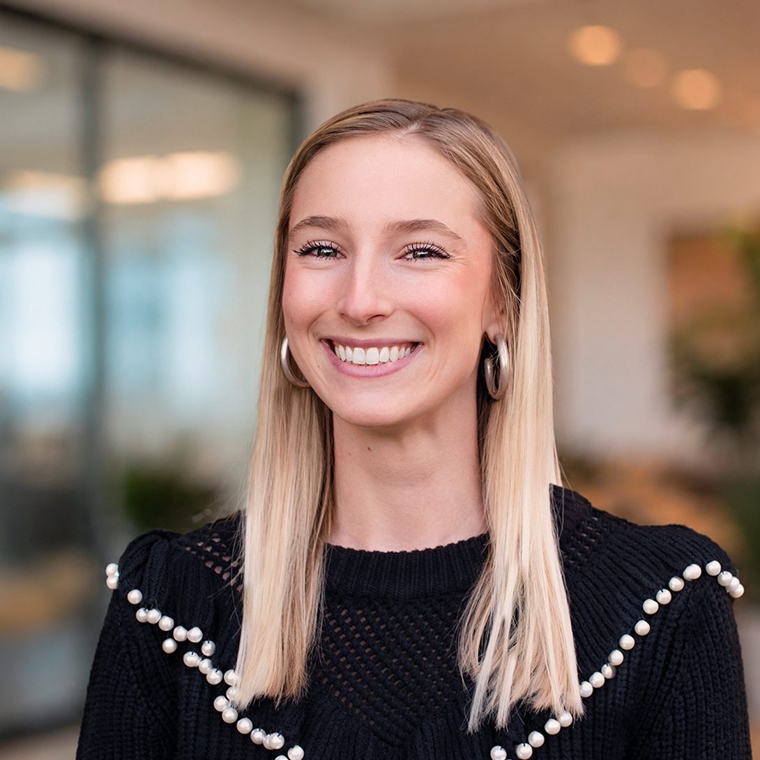 Morgan Lucas development manager young blonde woman smiling in an office setting in a black sweater
