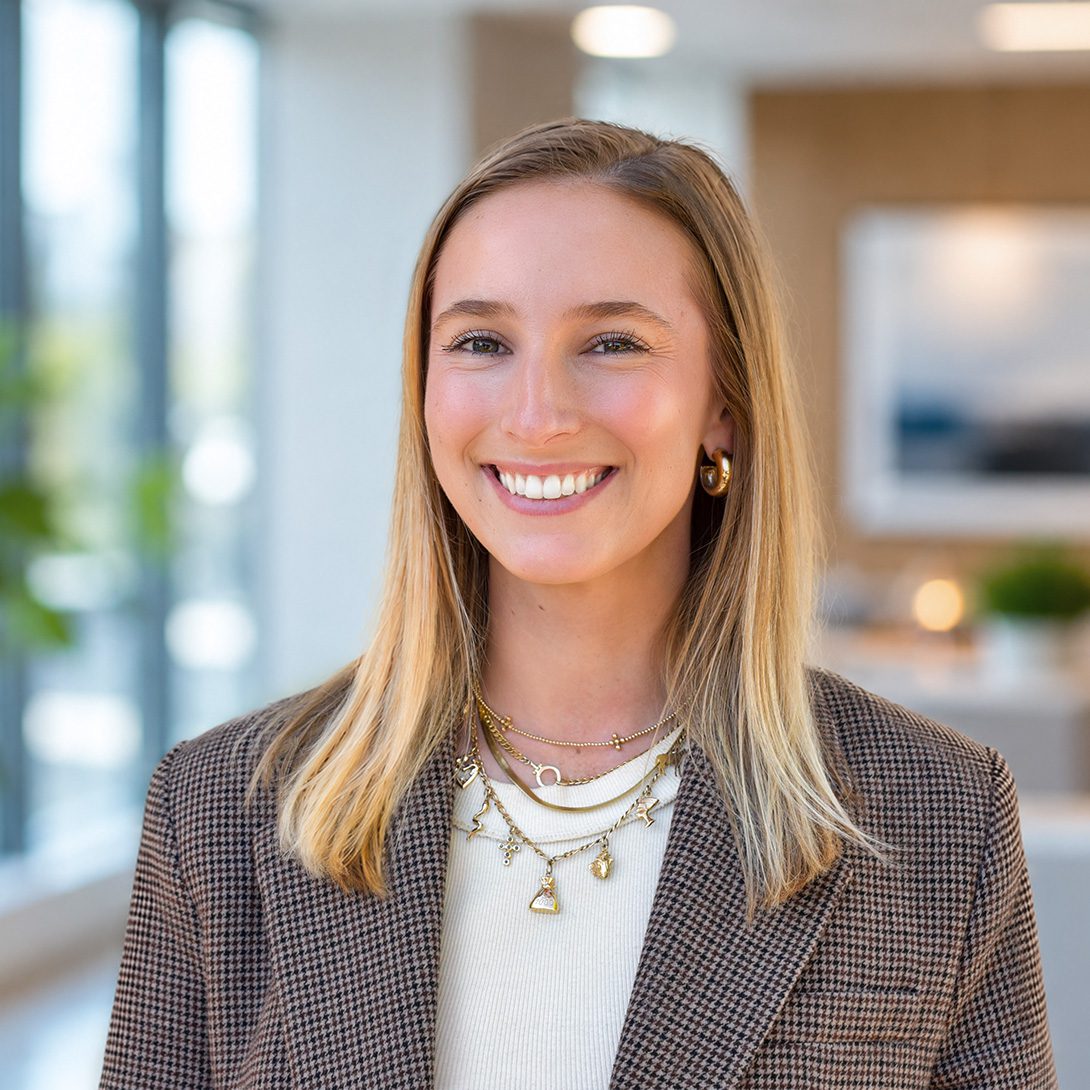 Morgan Luca young woman smiling inside an office in a tweed jacket