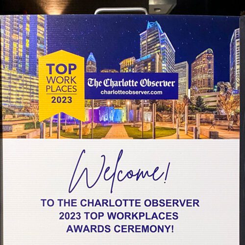 Top Workplaces outdoor event sign presented by The Charlotte Observer in the evening