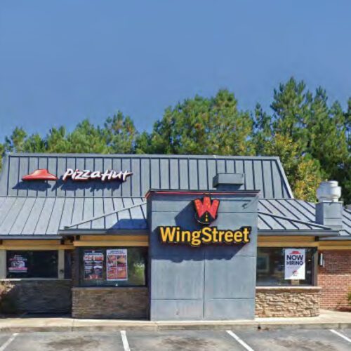 Pizza Hut Brick Building with Grey Roof and parking lot