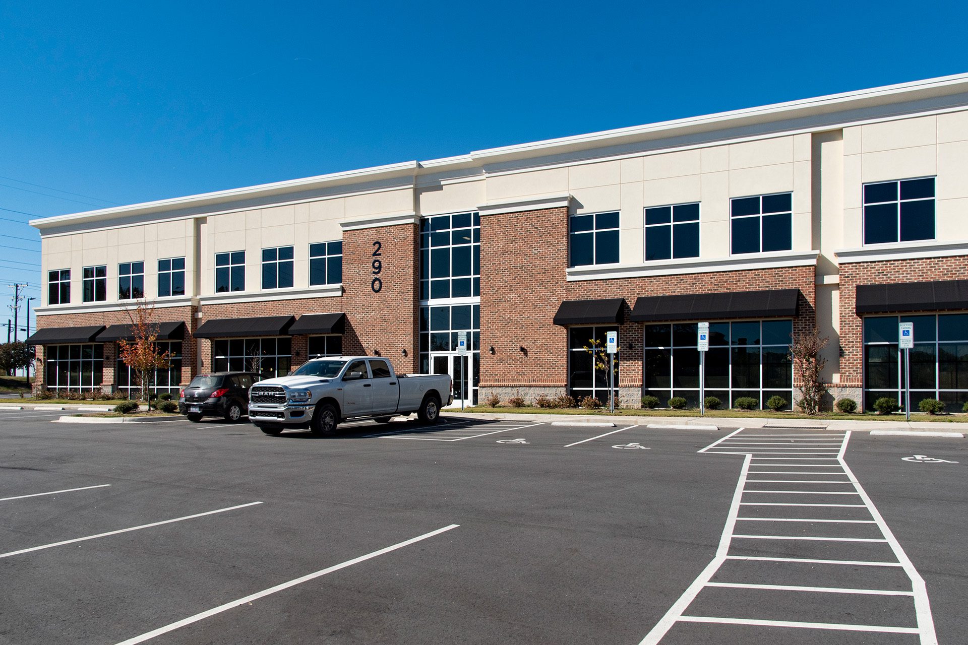 Exterior of a two story brick office building with paved parking lot