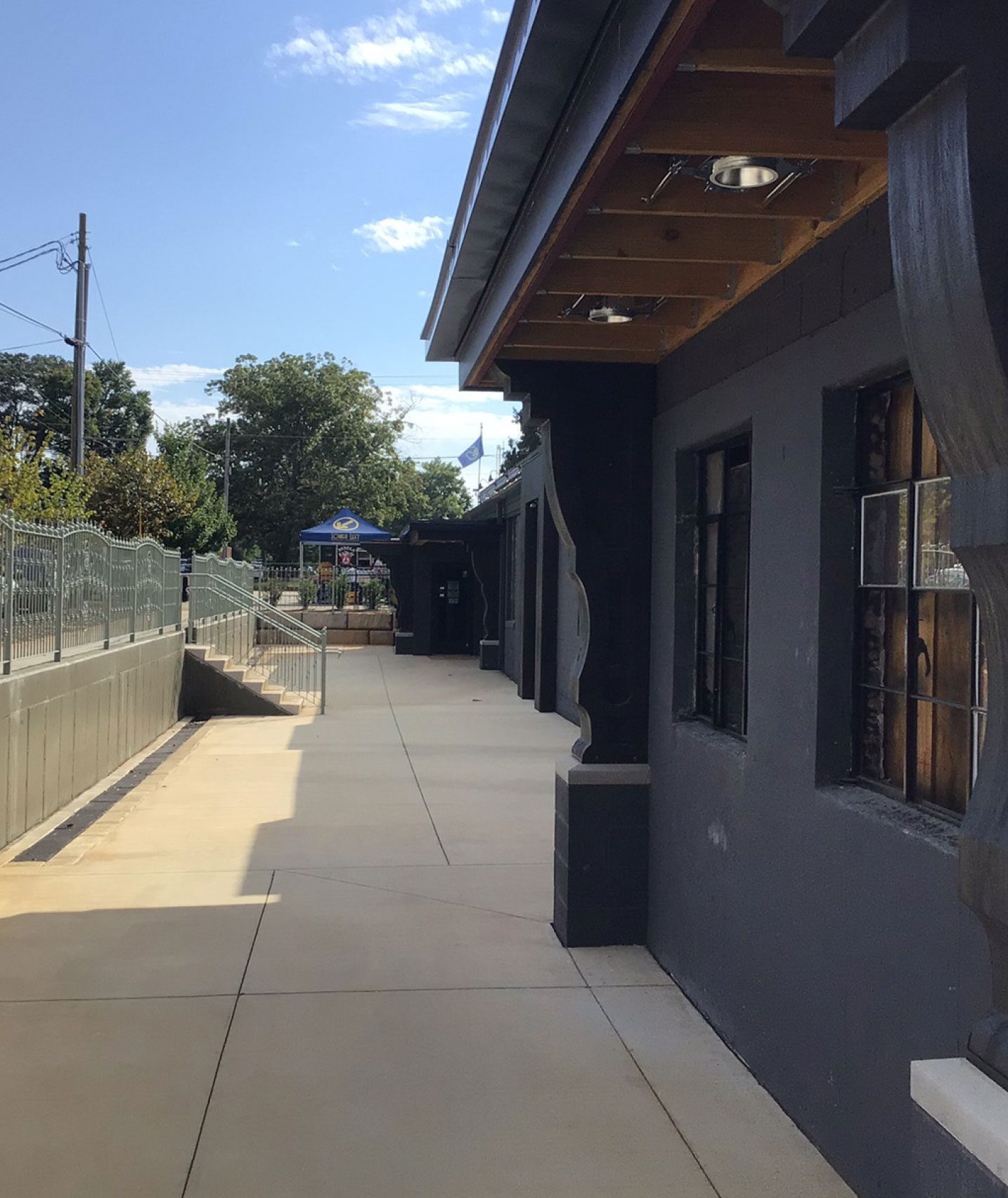Exterior of charcoal grey office building with sidewalk