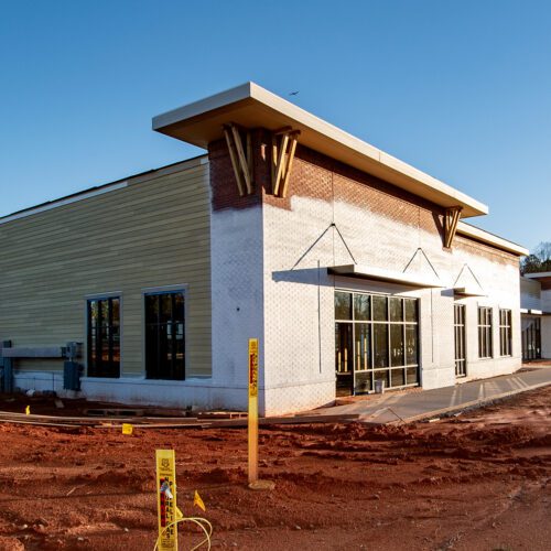 retail shop building under construction surrounded by red clay dirt