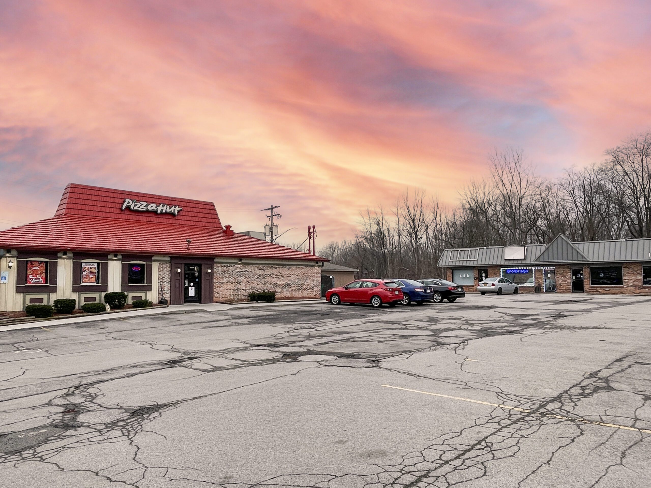 Brick Pizza Hut with cars in front