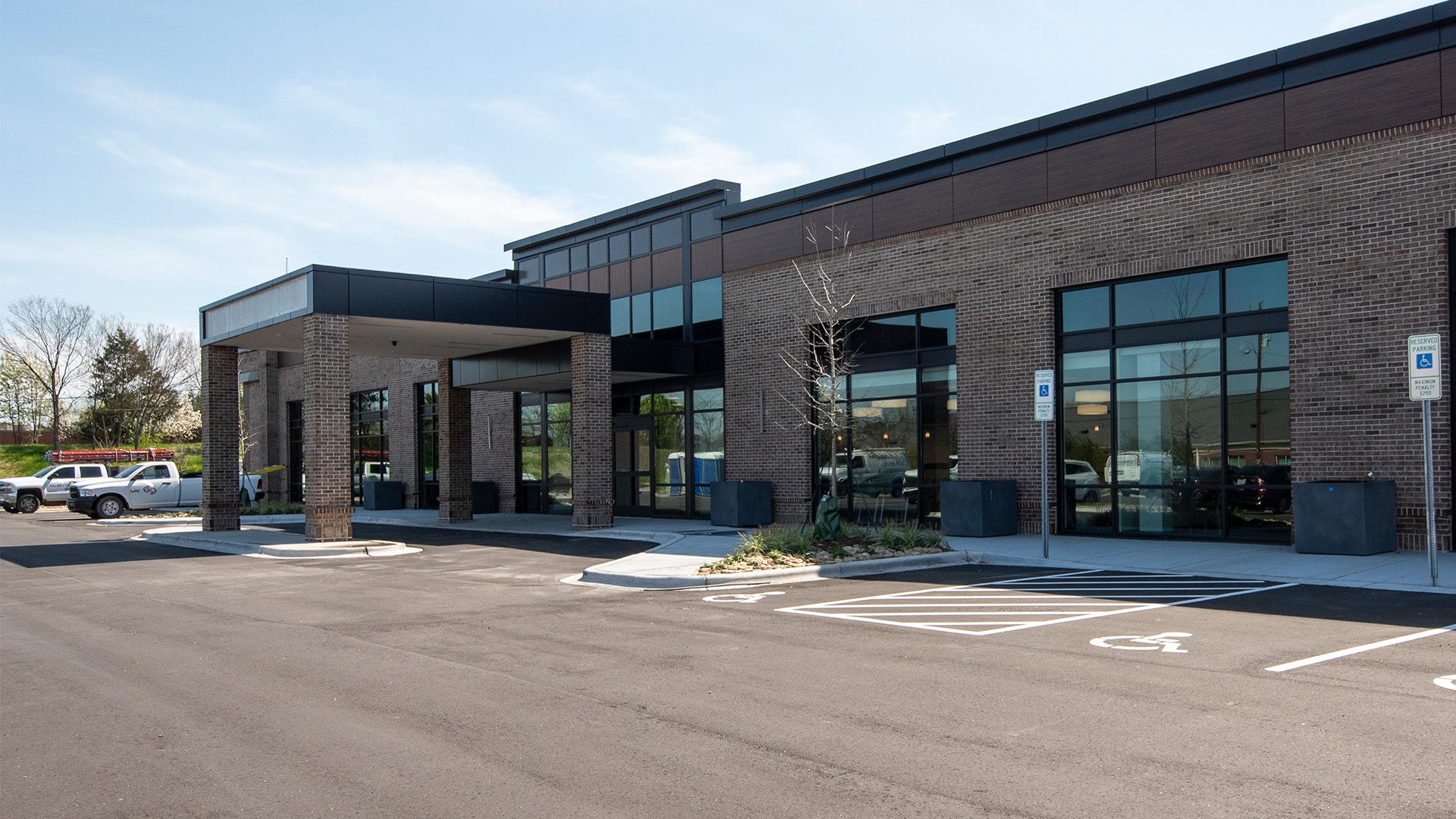 brick and black glass medical office building entrance with covered drive-thru awning