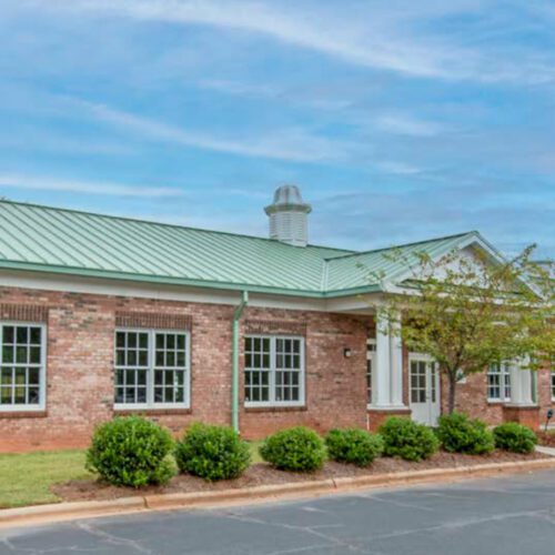 Brick building with green roof and parking lot