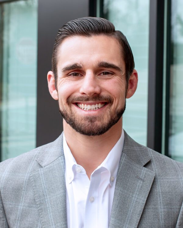 Chad Pyke white male with dark hair smiling outside an office building