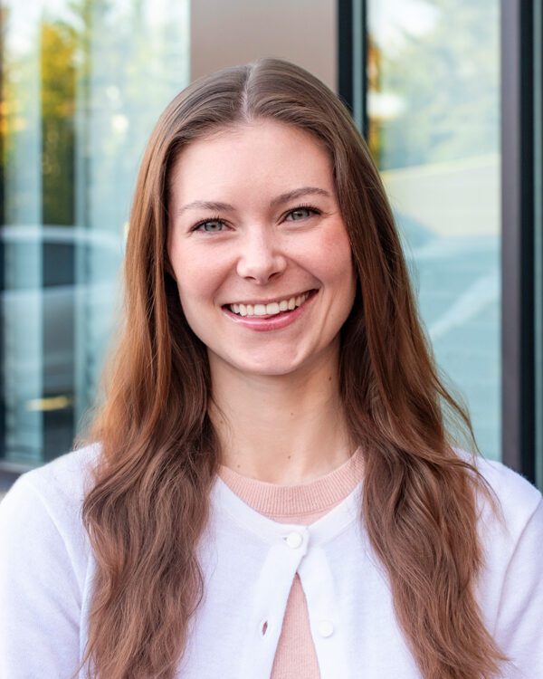 Ravanna Jackson young woman smiling outside with white cardigan and long light brown hair