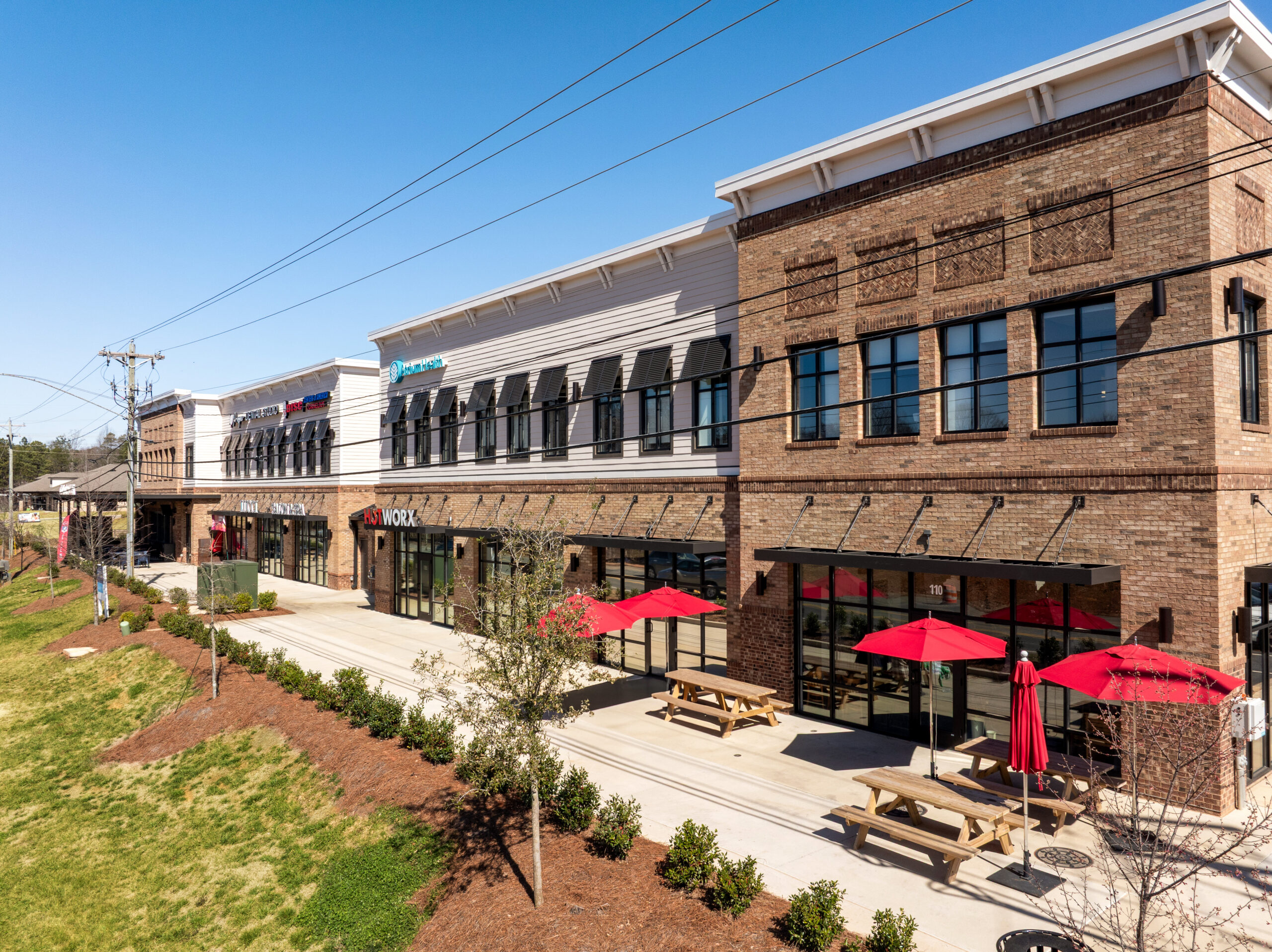 Brick Multi Tenant 2 story Building with parking lot with red umbrellas