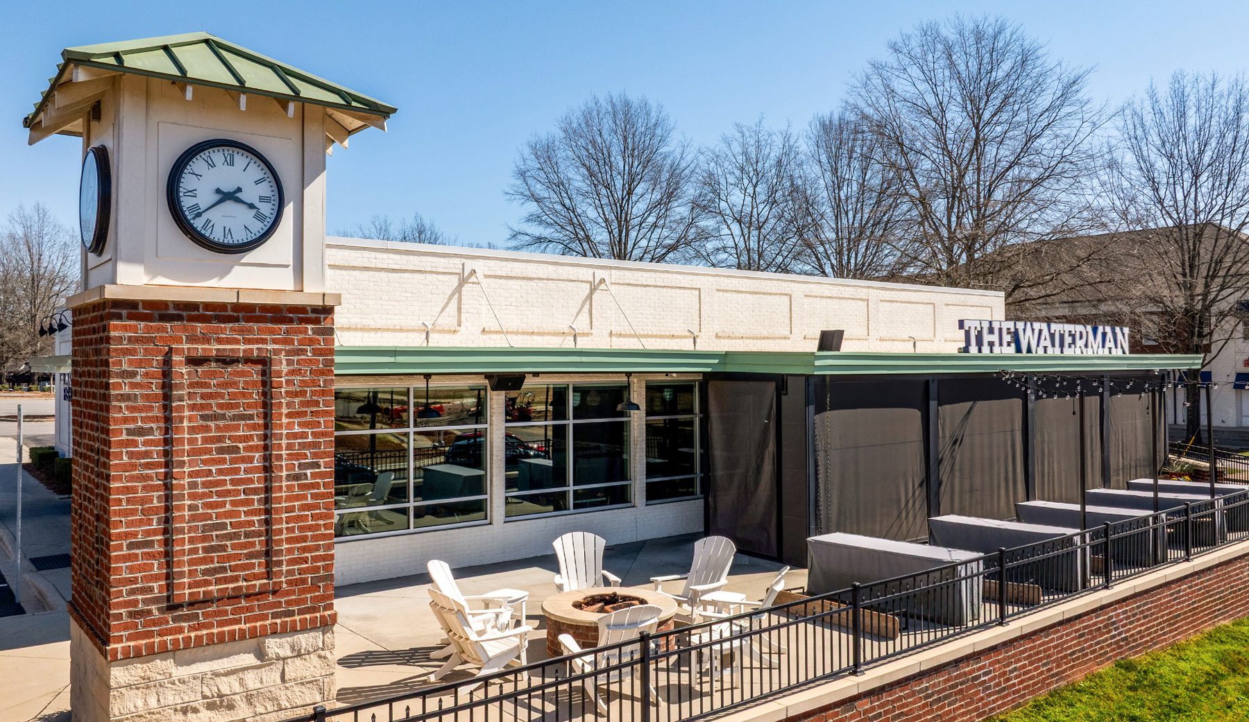 Exterior white and Brick building with patio and chairs
