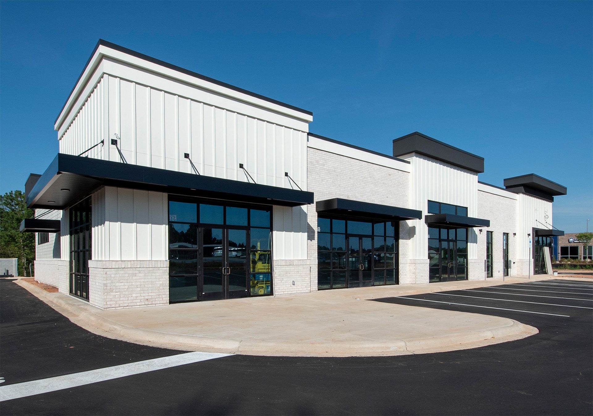 new construction multi-tenant retail or medical building with white exterior and black windows