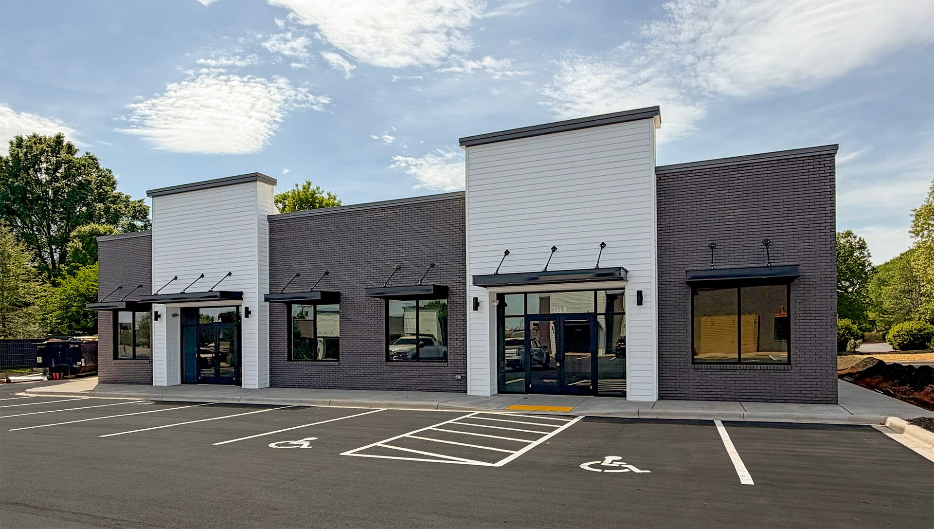 newly developed retail building commercial gray and white with black metal awnings