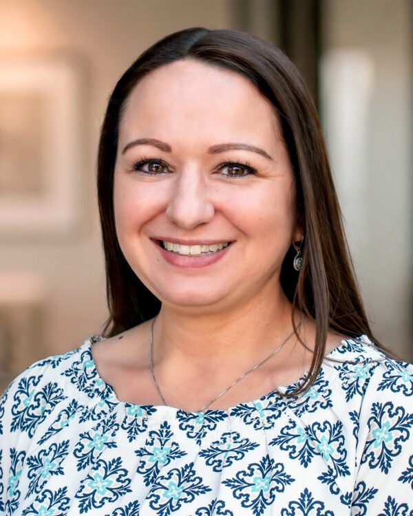 Sarah El-Zaatari smiling caucasian woman with long brown hair in a patterned blouse