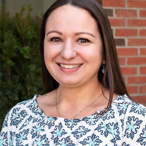 Sarah El-Zaatari smiling caucasian woman with long brown hair in a patterned blouse