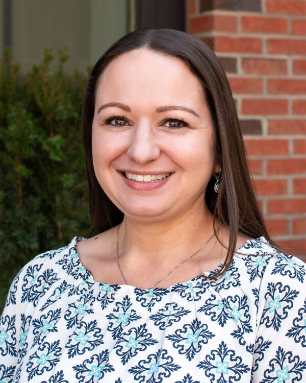 Sarah El-Zaatari smiling caucasian woman with long brown hair in a patterned blouse