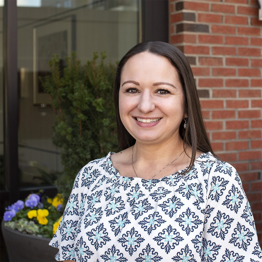 Sarah El-Zaatari smiling caucasian woman with long brown hair in a patterned blouse