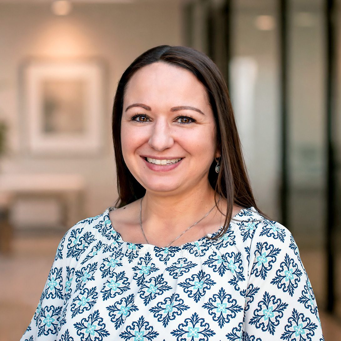 Sarah El-Zaatari smiling caucasian woman with long brown hair in a patterned blouse